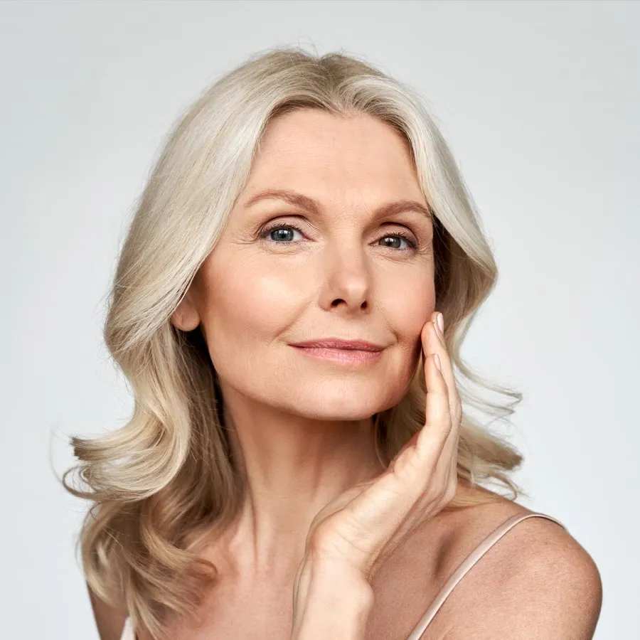 Blonde smiling woman year with clean fresh face and hands wit