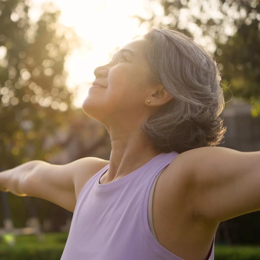Asia adult aged people middle age mindful happy old woman open arm yoga deep calm stress relief outdoor nature public park sun light self love relax elder aging life asian female mental health care.
