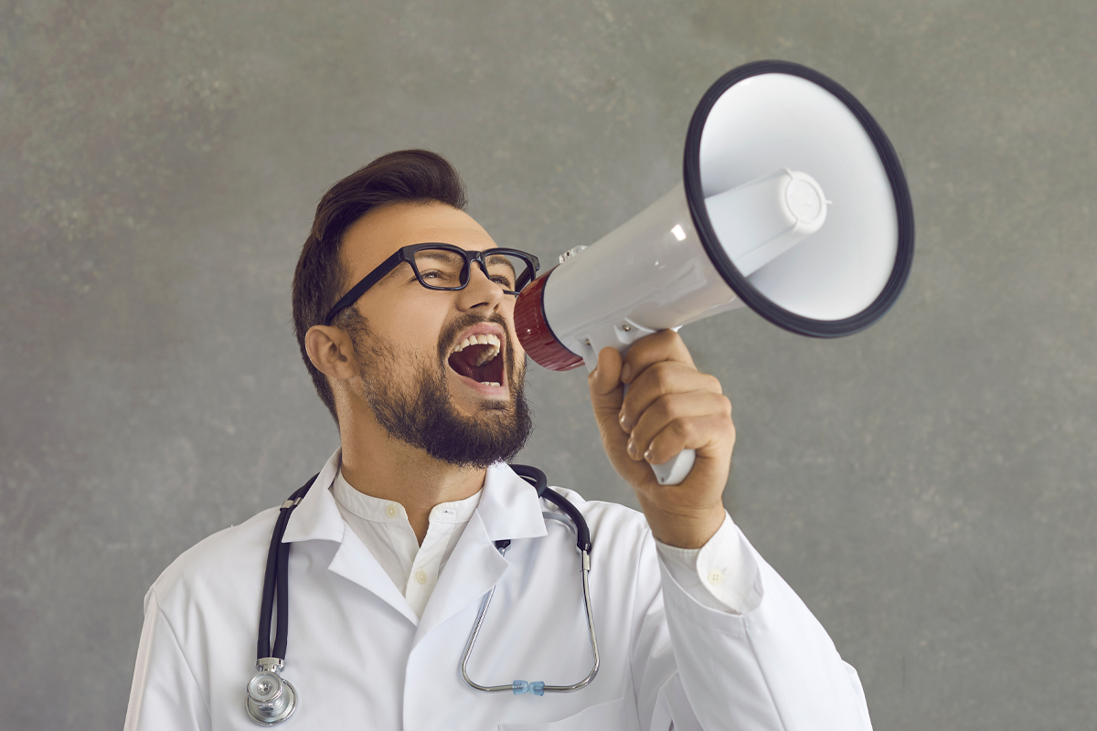 male doctor screaming shouting in megaphone to message heard