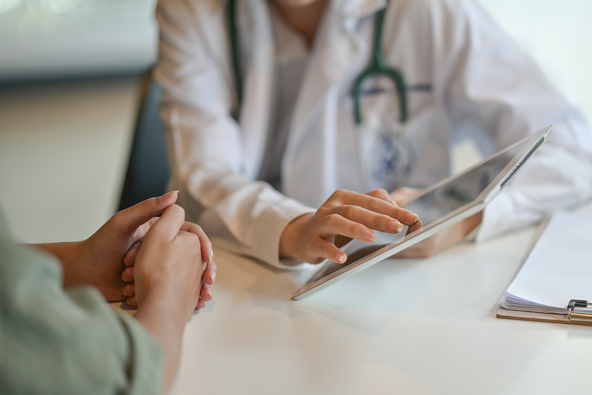 shot of a doctor showing a patient some information on a digital tablet